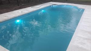 una piscina azul con luces. en Paraiso Serrano en La Población