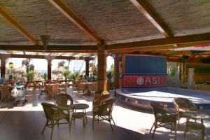 a restaurant with a pool and tables and chairs at Oasi Beach Hotel in Vieste