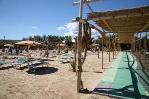 a beach with a bunch of chairs and umbrellas at Oasi Beach Hotel in Vieste