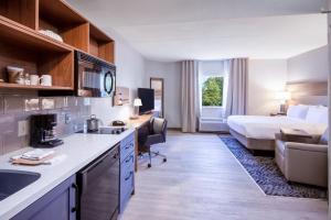 une chambre d'hôtel avec une cuisine et un lit dans l'établissement Candlewood Suites Manassas, an IHG Hotel, à Manassas