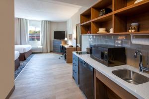 een keuken met een wastafel en een bureau in een kamer bij Candlewood Suites Manassas, an IHG Hotel in Manassas