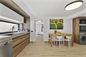 a kitchen with a wooden table and chairs and a dining room at Villa Atlantico - Planta Baja in Arrecife