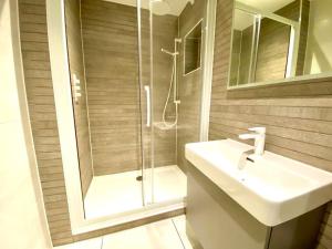 a bathroom with a shower and a sink and mirror at Stunning Apartment - 1 Minute walk to Poole Quay - Great Location - Free Parking - Fast WiFi - Smart TV - Newly decorated - sleeps up to 2! Close to Poole & Bournemouth & Sandbanks in Poole