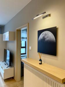 een kamer met een bureau met een foto van de maan bij Project Comfort Apartament Przasnyska 7/33 Warszawa in Warschau