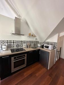 uma cozinha com um fogão e um micro-ondas em La suite Brésilienne em Forges-les-Eaux