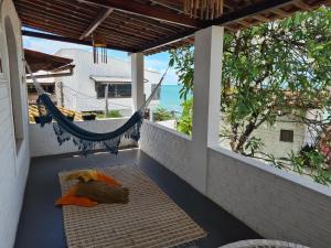 a porch with a hammock and a view of the ocean at Casa de Dan in Pipa