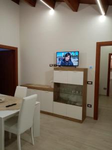 sala de estar con mesa y TV en la pared en casa Trignano, en Isola del Gran Sasso dʼItalia