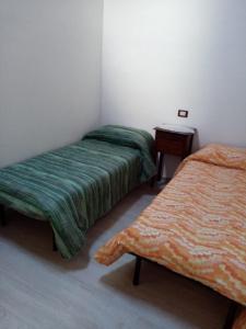 2 camas en una habitación con una mesa y una cama en casa Trignano, en Isola del Gran Sasso dʼItalia