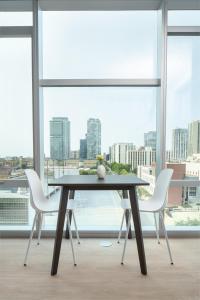 a dining room table with white chairs in front of a window at Kasa River North Chicago in Chicago