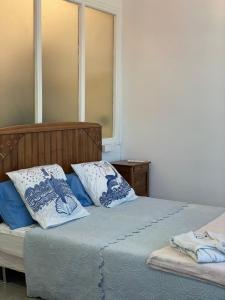 1 dormitorio con 2 camas y almohadas azules y blancas en Palais Hongran de Fiana, en Niza