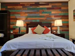 a bedroom with a bed with a wooden accent wall at Calathea Lodge Monteverde in Monteverde Costa Rica