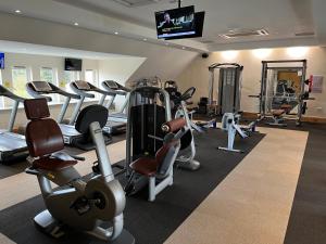 a gym with several tread machines and a flat screen tv at Pine Boutique Lodge with hot tub for couples & dog in York