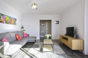 salon z kanapą i telewizorem w obiekcie Appartement Temerland - 4 étoiles - Welkeys w Biarritz