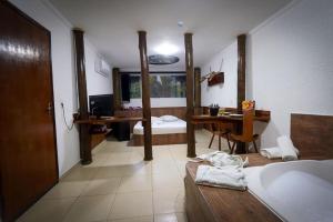 Motel Ipe في آراساريغواما: حمام مع حوض وغرفة نوم مع مكتب