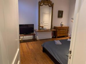 um quarto com uma cama, um espelho e uma cómoda em Albert Molière em Bruxelas