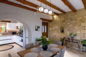 - une cuisine et une salle à manger avec une table et des chaises dans l'établissement Stone villa Halepa with panoramic view., à Néon Khoríon