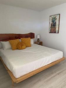 Retro motel walk to beach, Wi-Fi في دايتونا بيتش: غرفة نوم بسرير كبير مع مخدات صفراء
