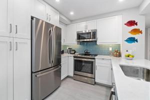a kitchen with white cabinets and a stainless steel refrigerator at Sst3 #1209 in Marco Island