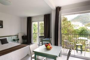 a bedroom with a bed and a balcony with a view at Appart Hotel Corte HR in Corte