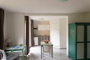 a kitchen with two tables and a table with a bowl of fruit at Appart Hotel Corte HR in Corte
