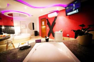 een kamer met een rode muur met een tv aan de muur bij Motel Ipe in Araçariguama