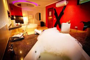 een badkamer met een wastafel en een rode muur bij Motel Ipe in Araçariguama +41 foto's