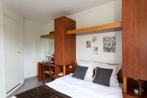 a bedroom with a bed with a wooden headboard at Appart Hotel Corte HR in Corte