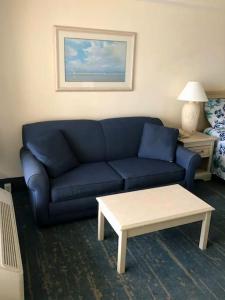 戴通納海灘的住宿－Beachin Oceanfront Studio，客厅配有蓝色的沙发和茶几