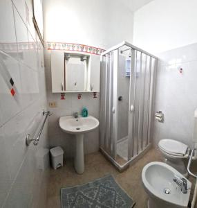 uma casa de banho com um lavatório, um chuveiro e um WC. em Case Pescatori em Lampedusa