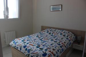 a bedroom with a bed with a colorful comforter at La Baraque in Gourhel