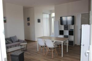 a kitchen and living room with a table and chairs at La Baraque in Gourhel