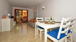 Una sala de estar con una mesa y sillas blancas. en Apartamento La Recoleta, en Torrevieja