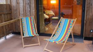 dos sillas de jardín sentadas frente a una tienda en CHALET VINTAGE - Les Belles Ouvrières, en Clermont-Créans