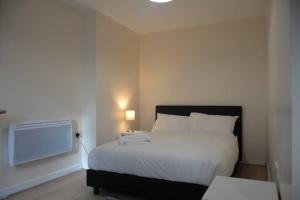 sypialnia z dużym białym łóżkiem i telewizorem w obiekcie London 4 Bedroom House w Londynie