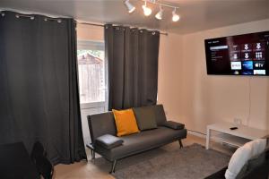 a living room with a couch and a window at London 4 Bedroom House in London