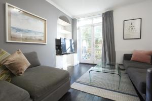 a living room with a couch and a tv at Walk to Notting Hill /Paddington 1 B/R with patio in London