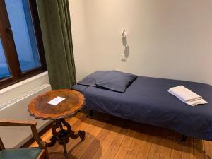 a bedroom with a bed and a table and a chair at Albert Molière in Brussels