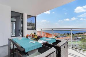 einen Balkon mit einem Tisch und Stühlen sowie Meerblick in der Unterkunft Apartment Nata by HR MADEIRA in Caniço