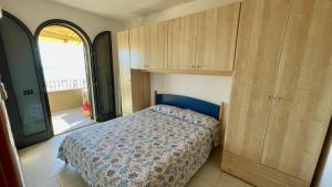 a bedroom with a bed and wooden cabinets at Appartamenti Lungomare Via Roma in Castiglione della Pescaia