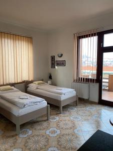 dwa łóżka w pokoju z dwoma oknami w obiekcie Apartmán Kaiser w Pradze