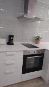 cocina blanca con fogones y fregadero en Estudio 2 PAX 140 m playa Caneliñas, (403), en Sanxenxo