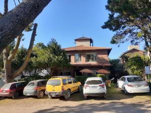 een groep auto's geparkeerd voor een huis bij Hosteria Luz de Luna in Valeria del Mar