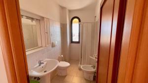a bathroom with a sink and a toilet and a sink at Appartamenti Lungomare Via Roma in Castiglione della Pescaia +95 photos
