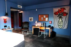um quarto com uma parede azul, uma secretária e uma cadeira. em Hotel Gaythering - Gay Hotel - All Adults Welcome em Miami Beach