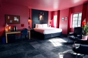 a red room with a bed and a desk and chairs at Hotel Gaythering - Gay Hotel - All Adults Welcome in Miami Beach
