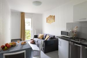 a kitchen and living room with a couch and a table at Appart Hotel Corte HR in Corte