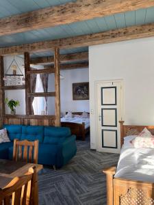 a living room with a blue couch and a bed at Vila Liberta in Poprad