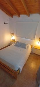 1 cama blanca en una habitación con 2 lámparas en Departamento en Mina en Mina Clavero