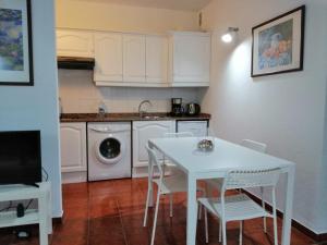 a kitchen with a white table and chairs and a washing machine at Casa Alisios in Playa de Santiago