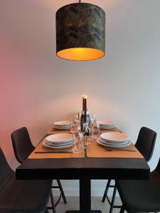 a dining room table with plates and a lamp at Red cross street in Lommel
